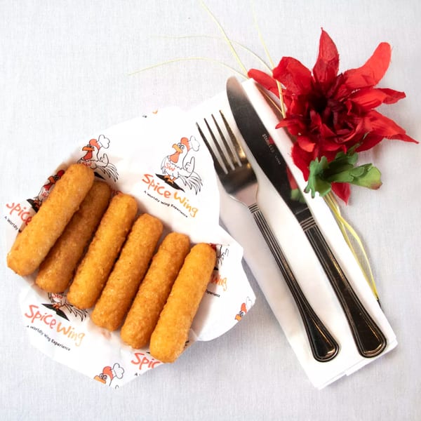 Spice Wing mozzarella sticks in branded paper, with cutlery and a red flower on a white tablecloth.