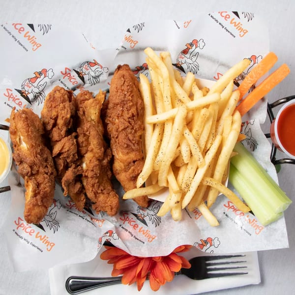 Spice Wing's fried chicken tenders and french fries, with celery, carrots, and dipping sauces.